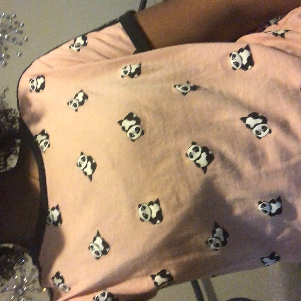 Pink shirt with adorable pandas and black stripes.